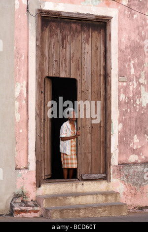 Cuban woman standing in doorway à Cienfuegos, Cuba, Antilles, Caraïbes, Amérique Centrale Banque D'Images