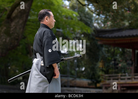 Homme tenant une épée samouraï réel au cours d'un exercice appelé sabre iaido kenjutsu ou lors d'une démonstration d'arts martiaux Banque D'Images