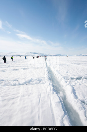 Vain hullu kalaa ( Seulement deux poissons ) Concours de pêche sur glace concurrents marche à Lac Kilpisjärvi Laponie Finlande Banque D'Images