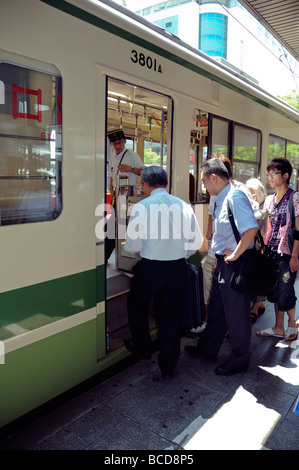 Les japonais de monter dans un train, Hiroshima, Japon Banque D'Images