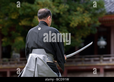 Homme tenant une épée samouraï réel au cours d'un exercice appelé sabre iaido kenjutsu ou lors d'une démonstration d'arts martiaux Banque D'Images