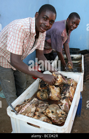 Deux jeunes cuisiniers préparer les têtes de moutons dans Otjikaendu Den Restaurant à Katutura Canton Central, Windhoek, Namibie Banque D'Images