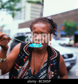 Une femme noire street vendeur qui détient une cuillère et cristaux bleu odeur dans Harlem New York Juin 2009 KATHY DEWITT Banque D'Images