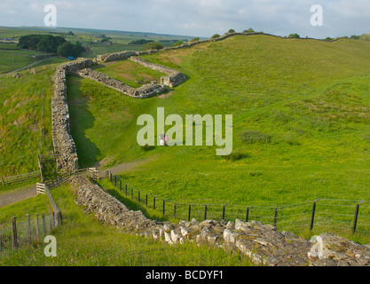 Deux personnes marchant vers Milecastle 42 sur le mur d'Hadrien, Cawfield, Parc National de Northumberland, England UK Banque D'Images