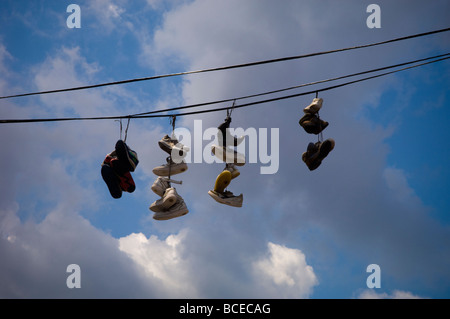 Chaussures suspendues à des câbles aériens dans une rue de Bushwick Brooklyn à New York Banque D'Images