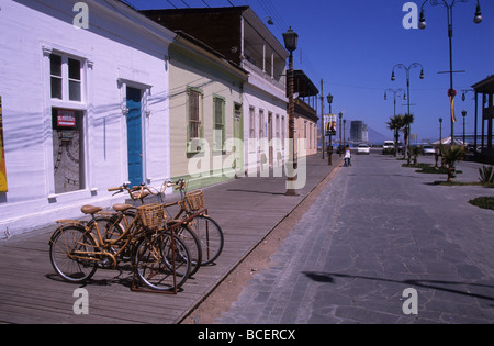 Vélos à l'ancienne et maisons traditionnelles en bois dans la rue Baquedano, Iquique, Chili Banque D'Images