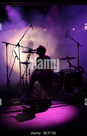 C'est la silhouette d'un rock and roll band batteur jouant et chantant. Banque D'Images