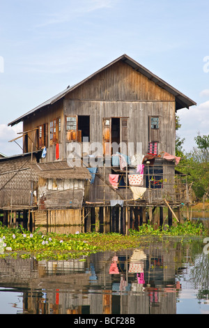 Le Myanmar, Birmanie, le lac Inle. Une ethnie Intha typique maison en bois sur pilotis dans le lac Inle, pittoresquement abritée par les montagnes. Banque D'Images