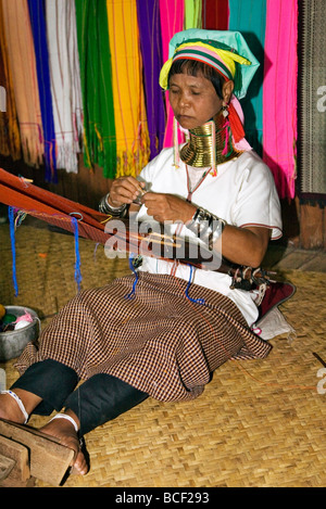 Le Myanmar, Birmanie, le lac Inle. Padaung une femme portant un collier en laiton lourd tissu tisse sur un métier à tisser simple. Banque D'Images