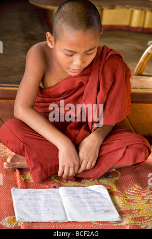 Le Myanmar, Birmanie, le lac Inle. Un jeune moine novice dans un monastère d'apprentissage l'école sur le lac Inle. Banque D'Images