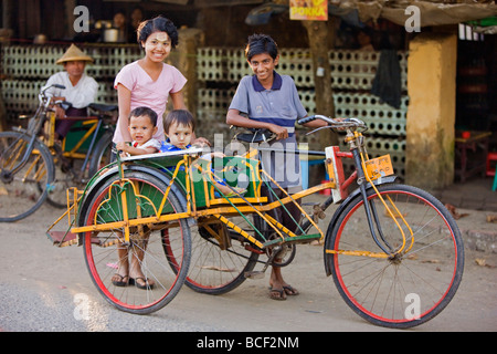 Le Myanmar, Birmanie, Sittwe. Une famille birmane prend la route de Sittwe en un trishaw, un moyen populaire de transport. Banque D'Images