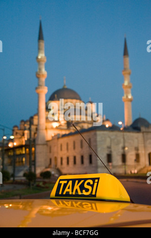 Un taxi jaune Taksi dans la cabine avant de la Yeni Cami nouvelle mosquée à Istanbul Turquie Banque D'Images