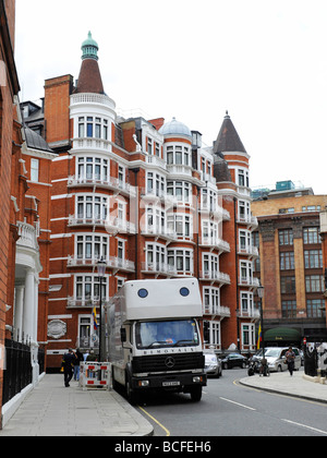 Les absorptions van à l'extérieur d'un bloc d'appartements luxueux hôtel particulier à Knightsbridge avec Harrods store dans l'arrière-plan Banque D'Images