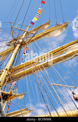 Jusqu'à la marine à voile au mât et gréement avec lignes, vergues, drapeaux, flèche, espars et ciel bleu Banque D'Images