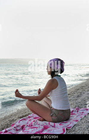 Young woman doing yoga on beach Banque D'Images