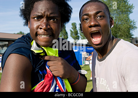 Deux mâles noir crazy heureuse célébration marquant un but à la young football 5 jeu de côté à un week-end de vacances Banque D'Images