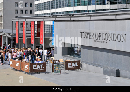 Les visiteurs assis à des TABLES de RESTAURANT en plein air à la Tour de Londres avec des guichets au-delà Banque D'Images