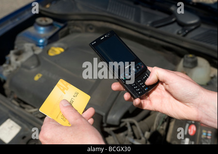 Close up de quelqu'un à l'aide d'un téléphone portable sonne l'aa automobile association à la suite d'une panne de voiture Banque D'Images