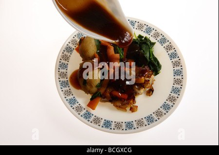 Dîner de poulet sur la plaque avec de la sauce étant versé sur Banque D'Images