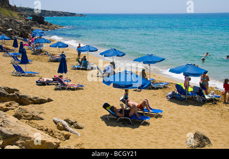 Les touristes se détendre sur les chaises longues et parasols sur la petite plage Ammes Beach sur l'île grecque de Céphalonie, Grèce GR Banque D'Images