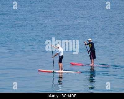 Stand up paddleboarding sur une mer plate Banque D'Images