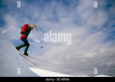 Cross Country Skier Jumping off Ridgeline SC Alaska Banque D'Images