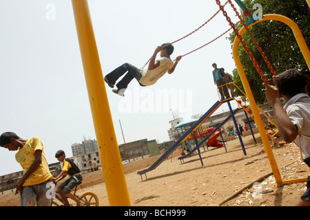 Les enfants jouent sur un ensemble de balançoires nouvellement construit à Dharavi, le plus grand bidonville de Mumbai (Bombay) en Inde Banque D'Images