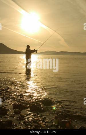 Pêche à la mouche l'homme rive de la baie Sitka SE AK de l'été près de Harbour Pt Silhouette Banque D'Images