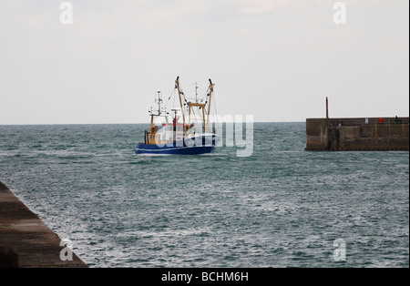 Un bateau de pêche rentrer au port Banque D'Images