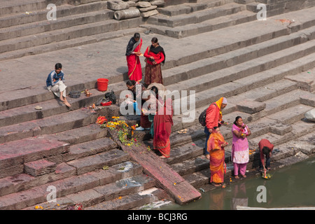 Temple de Pashupatinath, Népal. Les membres de la famille offrir des prières et offrandes de nourriture pour les personnes décédées sur la rive de la rivière Bagmati. Banque D'Images