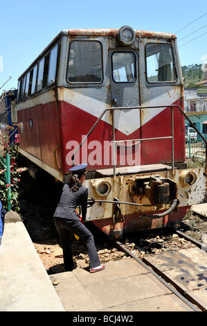 Réglage de la garde des femmes l'accouplement sur une très vieille locomotive diesel. La gare de Da Lat, Da Lat, Viet Nam Banque D'Images