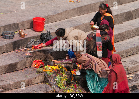 Temple de Pashupatinath, Népal. Les membres de la famille offrir des prières et offrandes de nourriture pour les personnes décédées sur la rive de la rivière Bagmati. Banque D'Images