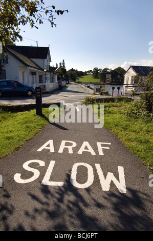 En route au Pays de Galles avec word 'ARAF - lent' peint sur tarmac. Banque D'Images