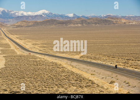 Nevada l'autoroute 50, route droite dans désert, route est connu comme 'plus solitaire dans l'autoroute du Nord' des montagnes enneigées au loin. Banque D'Images