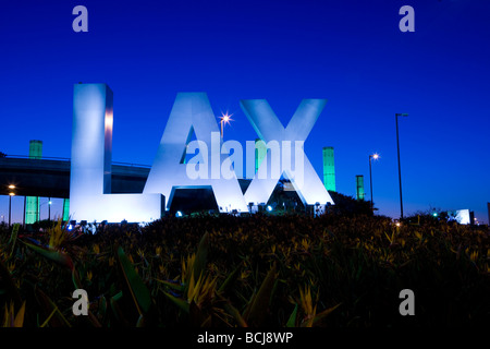 Signe tridimensionnel énonçant "LAX" à l'entrée de l'Aéroport International de Los Angeles à Los Angeles, Californie, au crépuscule. Banque D'Images
