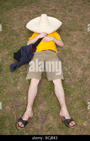 L'homme dormir sous un chapeau mexicain géant à Glastonbury Festival 2009 Banque D'Images