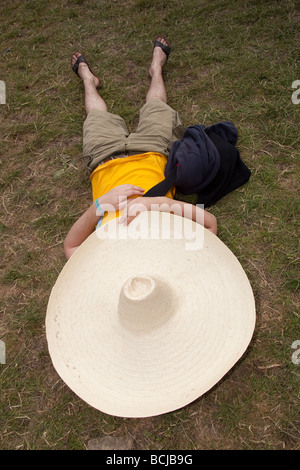 L'homme dormir sous un chapeau mexicain géant à Glastonbury Festival 2009 Banque D'Images