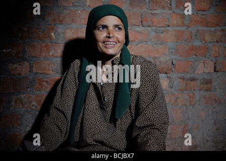 Une femme dans sa maison dans un village rural de l'Oasis du Fayoum en Égypte. Sa famille a des chèvres et des lapins sur le toit. Banque D'Images