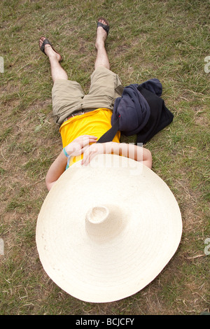 L'homme dormir sous un chapeau mexicain géant à Glastonbury Festival 2009 Banque D'Images
