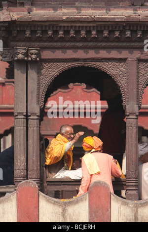 Pashupatinath, Népal. Un Sadhu, un ascète hindou ou saint homme, bénit un adorateur. Banque D'Images