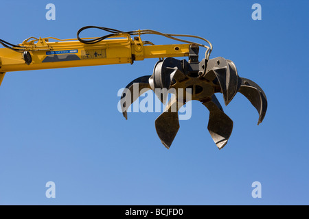 Griffe du mécanique jaune machine utilisée pour ramasser la ferraille à recylcing yard contre ciel bleu Indio Californie USA Banque D'Images