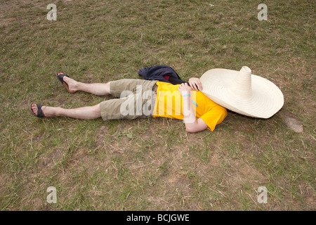 L'homme dormir sous un chapeau mexicain géant à Glastonbury Festival 2009 Banque D'Images