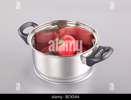 Tomate rouge dans un pot en acier inoxydable Banque D'Images