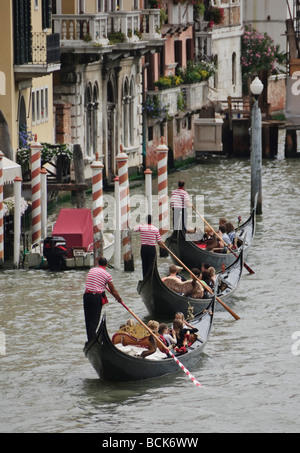 Venise - gondoles et gondoliers trois dans une rangée sur le Grand Canal - avec tous les costumes synchronisés Banque D'Images