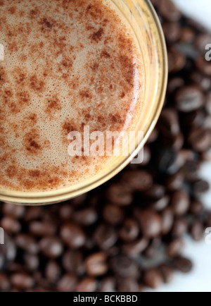 Latte Macchiato en verre sur l'établissement des coûts des grains de café Banque D'Images