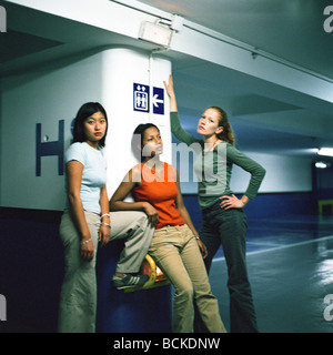 Les jeunes femmes debout dans un garage de stationnement Banque D'Images