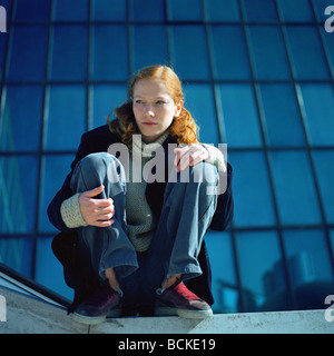 Scène urbaine, jeune femme assise Banque D'Images