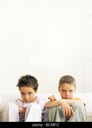 Deux enfants assis côte à côte Banque D'Images