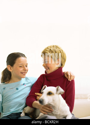 Deux filles assis avec dog on sofa Banque D'Images