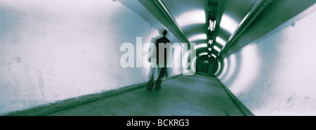 Homme marchant dans un passage souterrain, vue panoramique Banque D'Images